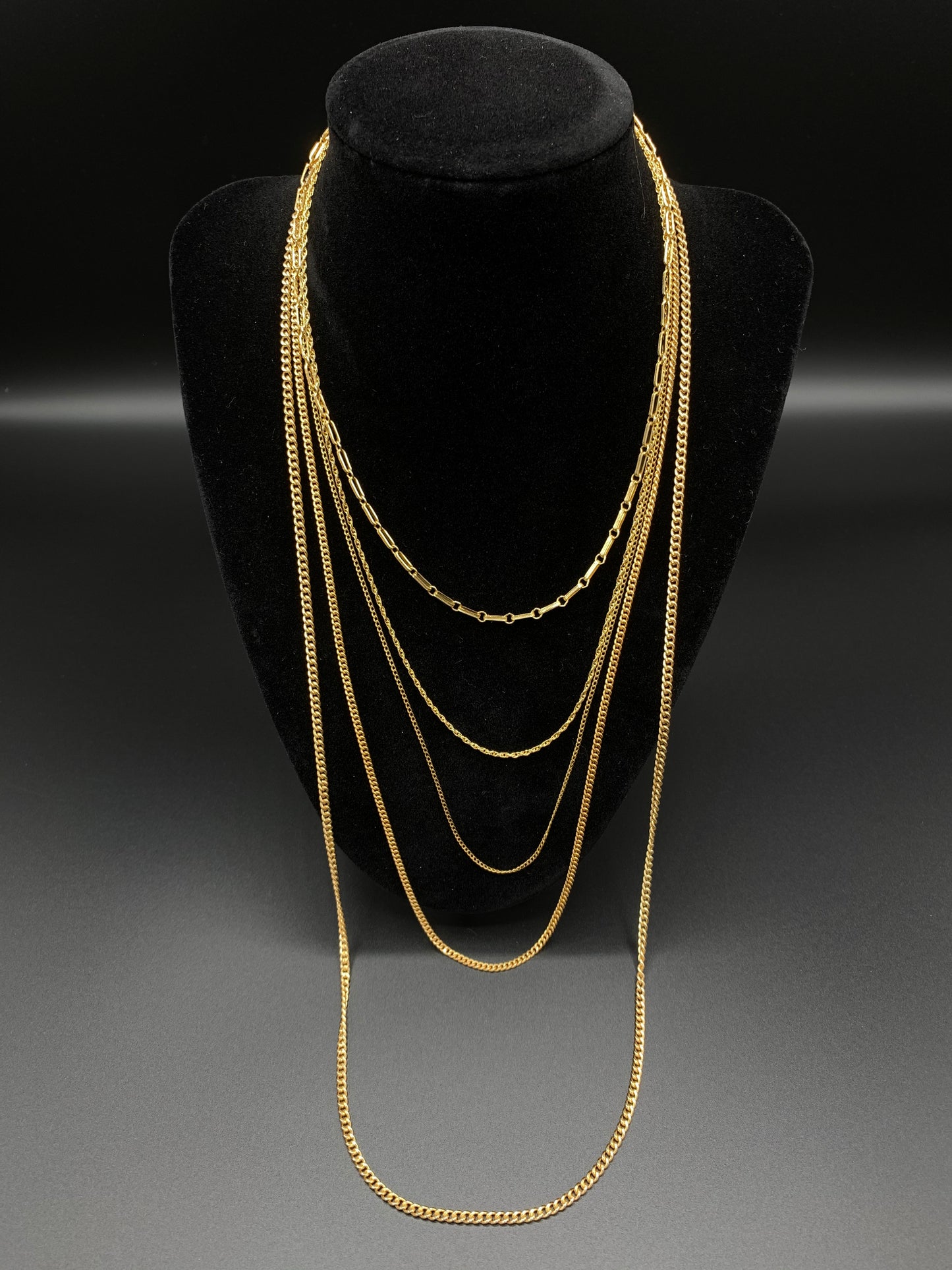 30 Inch Curb Link Chain layered with 15 Inch Anchor Chain, 18 Inch Rope Chain, 21 Inch Curb Link Chain, and 24 Inch Curb Link Chain